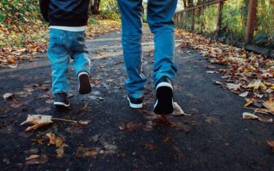 Photo d'un papa et son fils en train de marcher sur une route