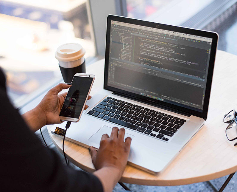 Photo qui représente l'agilité d'une personne en train de coder et de vérifier sur mobile le résultat