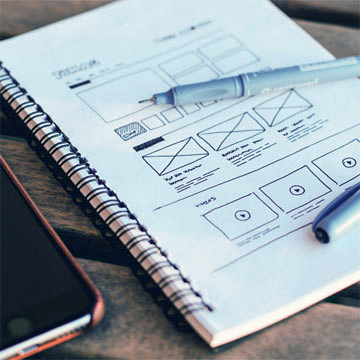 Un carnet de note avec un croquis fait à la main pour représenter un parcours utilisateur